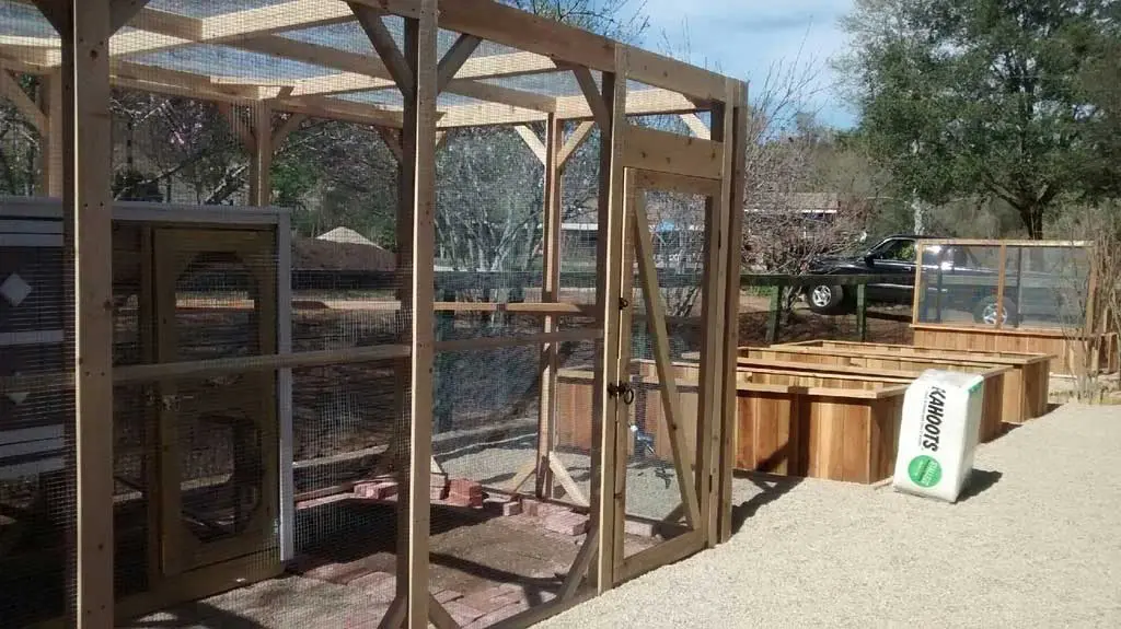 A chicken coop with a wooden frame.