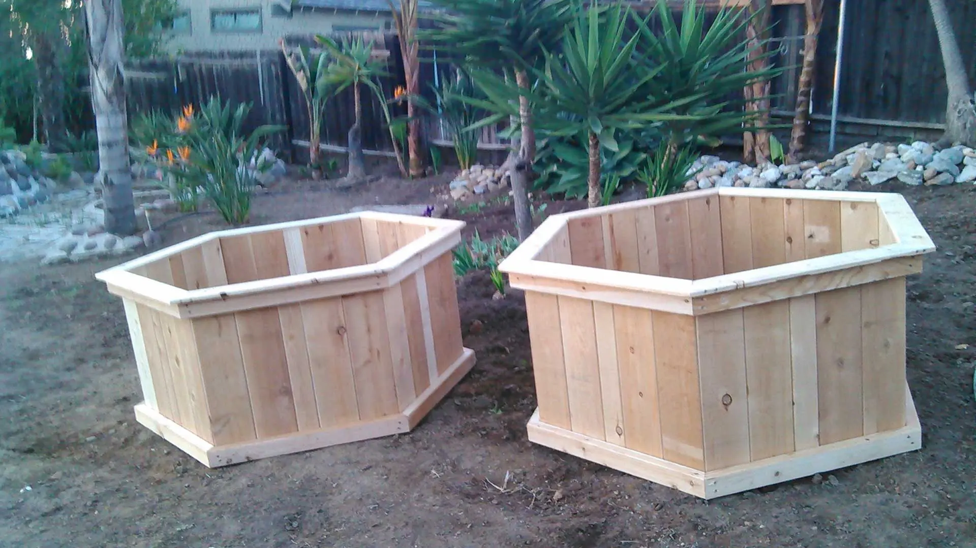 Two wooden planters on the ground.