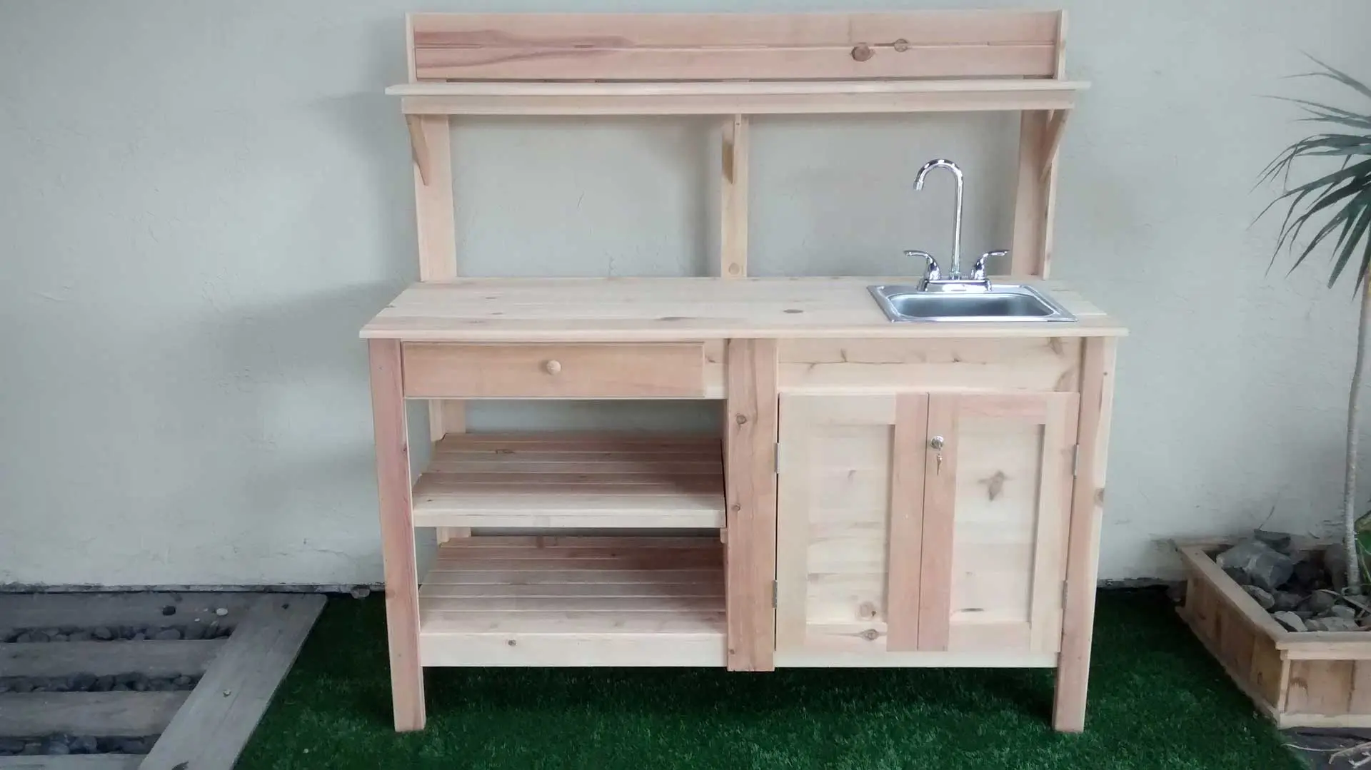 A wooden table with a sink and shelves