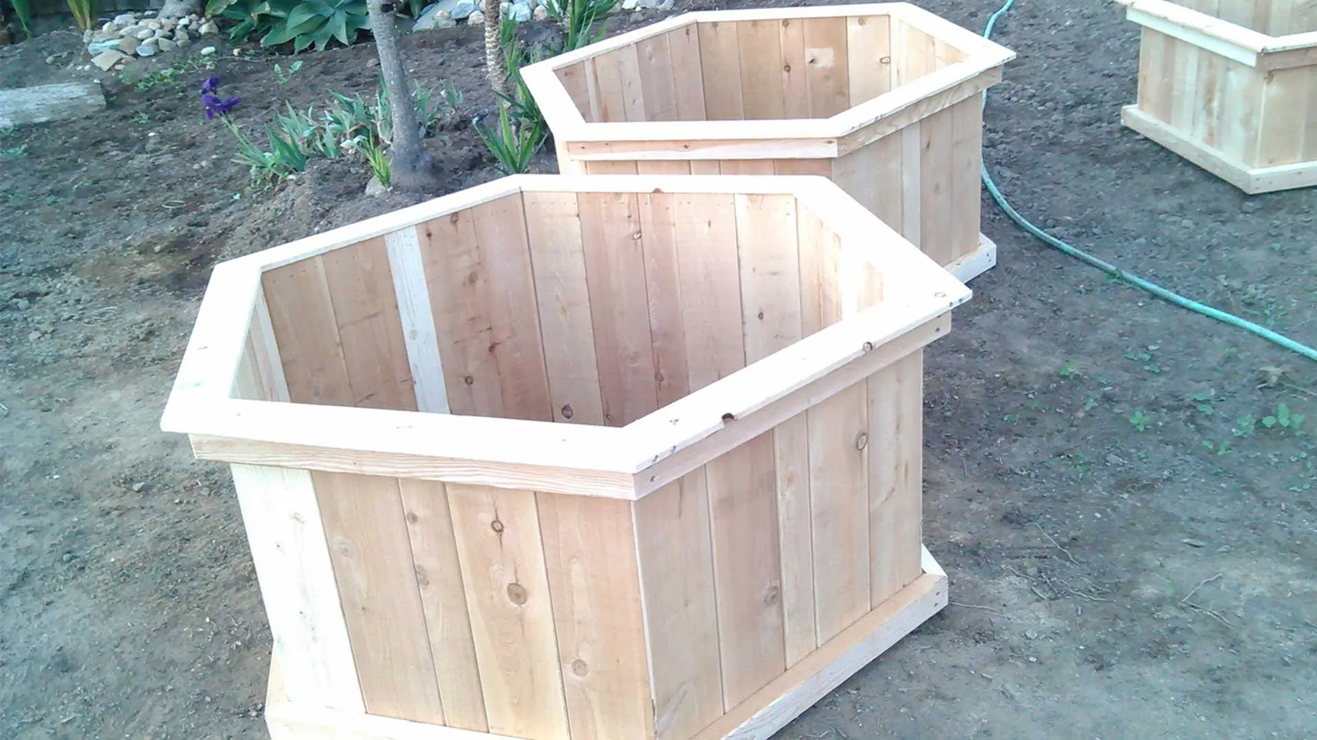 A set of wooden planters in the dirt.