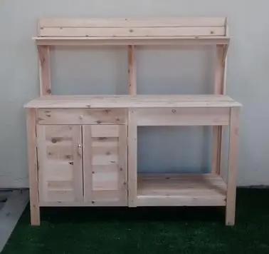 A wooden potting bench with two drawers and a shelf.