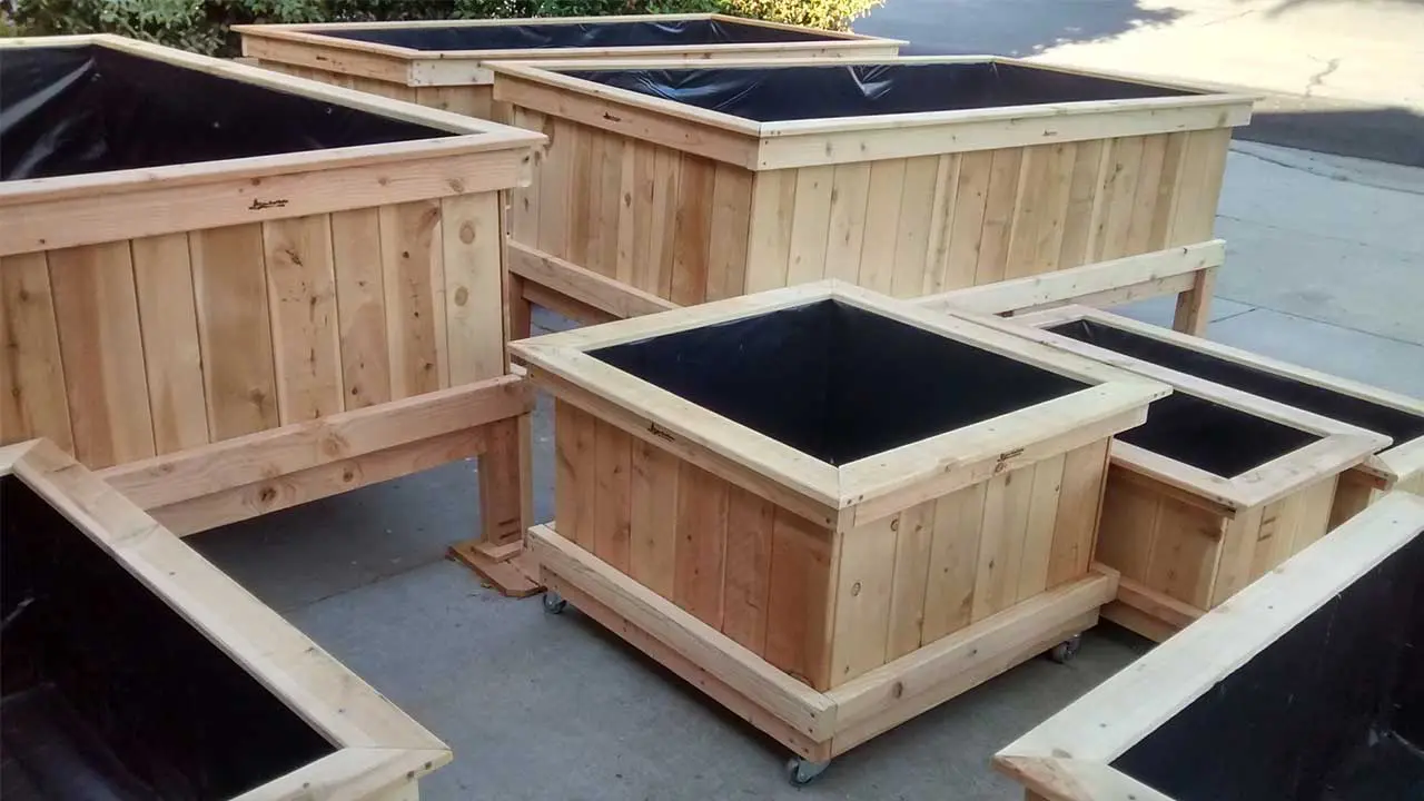 A group of wooden planters sitting on top of cement.
