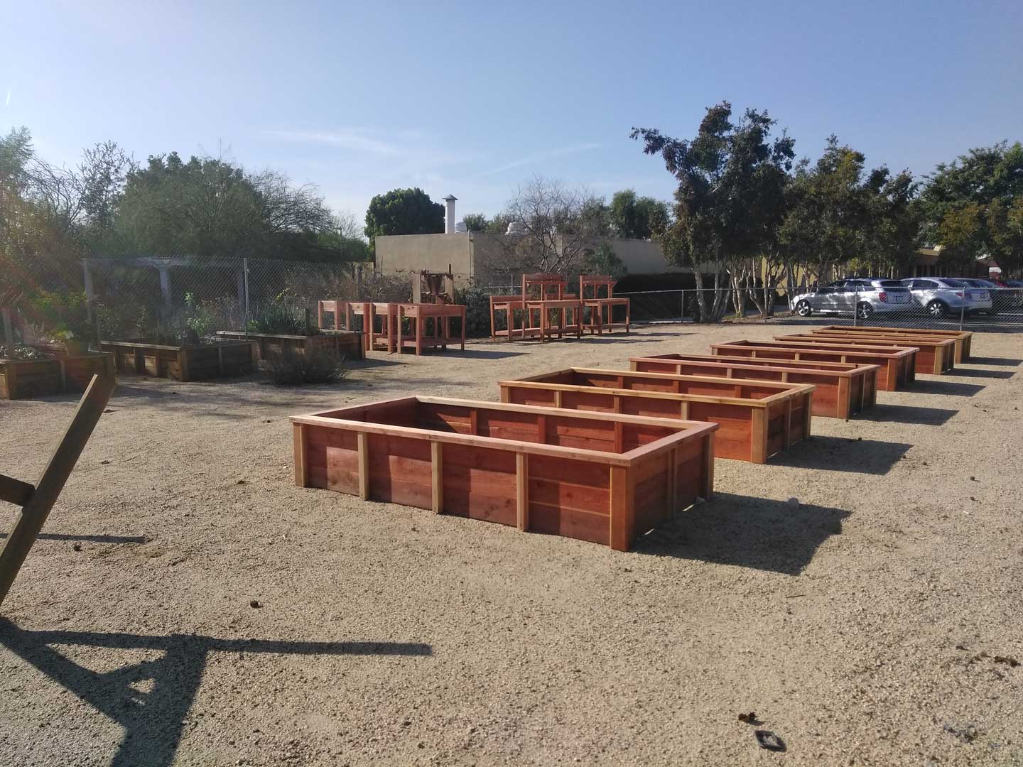 A group of wooden raised beds in a dirt lot.