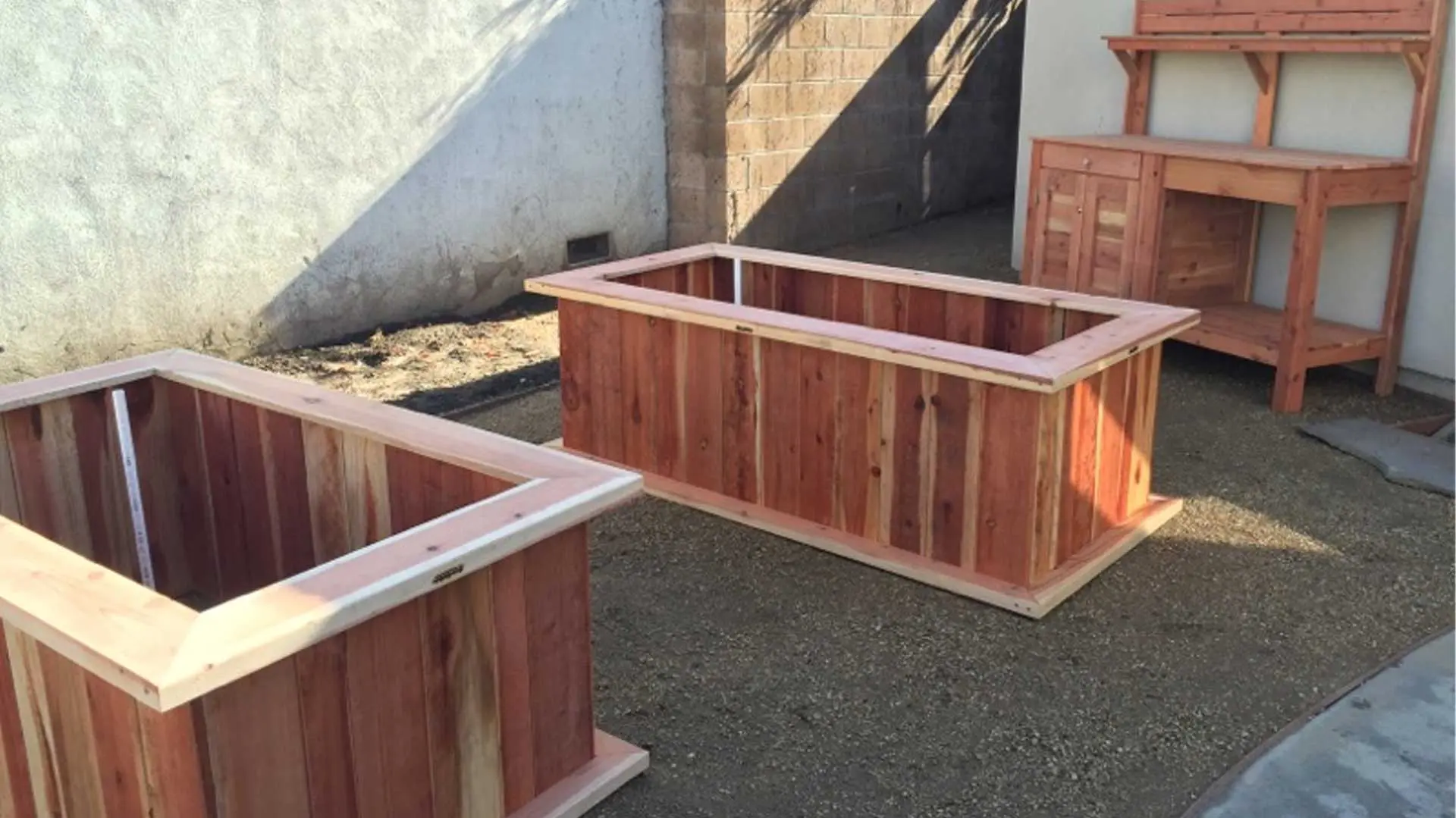 Two wooden planters in a backyard.