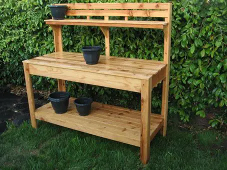 A wooden potting bench with pots on it.