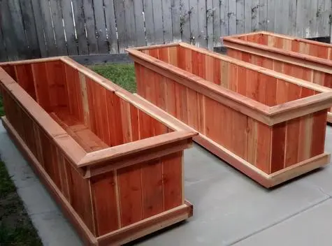 Three wooden planters sitting on a patio.