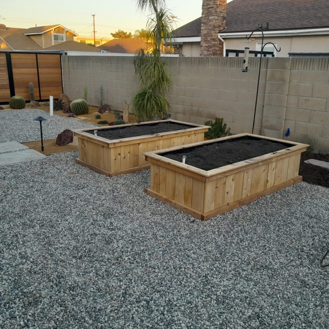 Two wooden garden beds filled with soil.