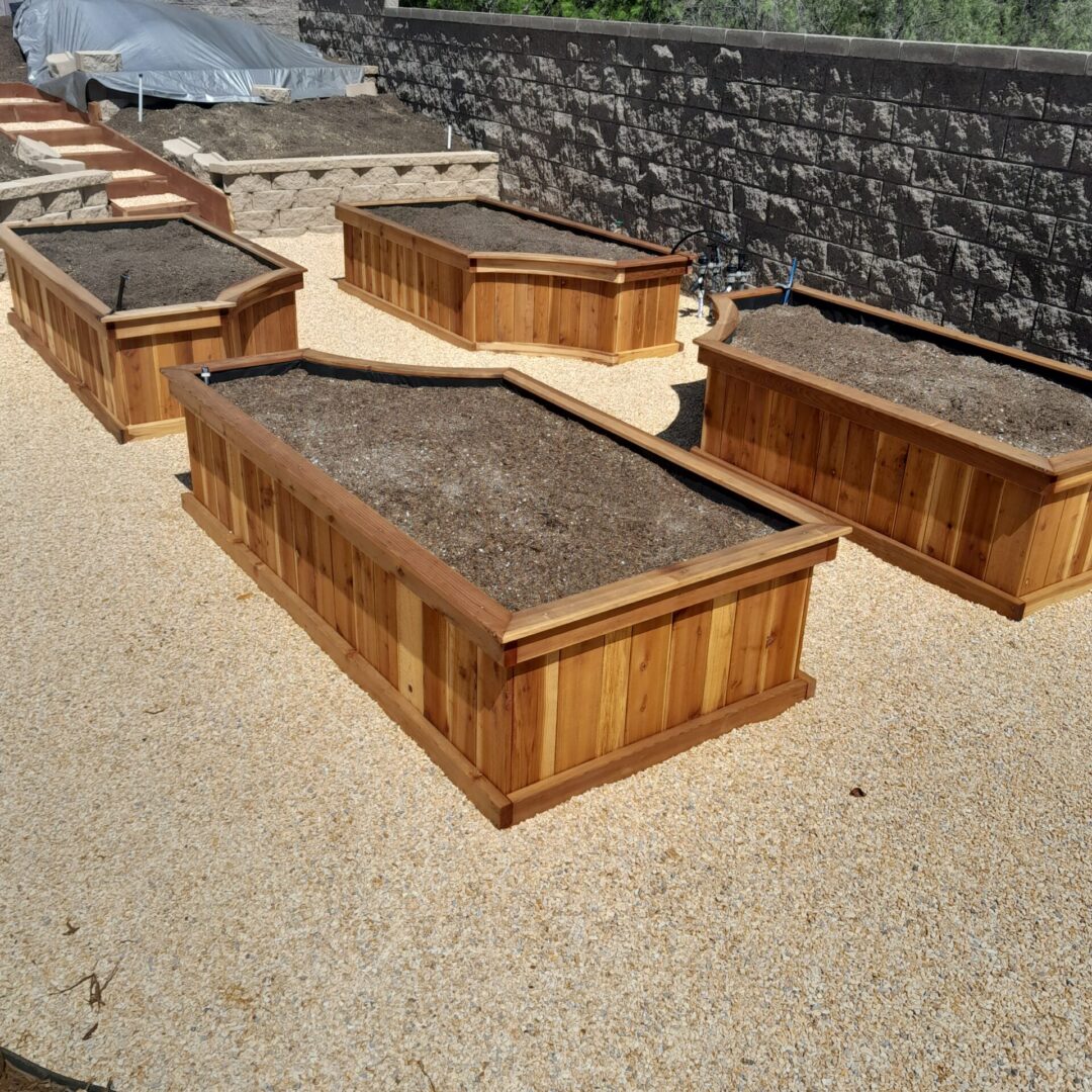 Four wooden garden beds filled with soil.